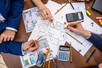 professional architects discussing the house project with work tools.