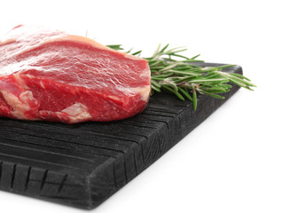 Cutting board with raw steak and spices on white background
