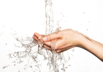 Closeup female hands under the stream of splashing water