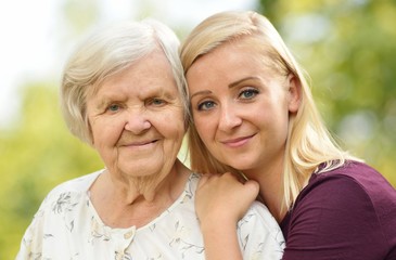 Grandmother and granddaughter. Young woman carefully takes care of an older woman.