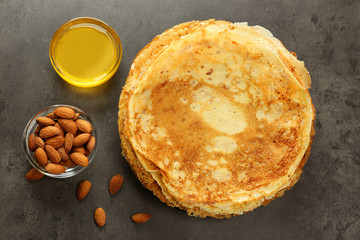 Delicious pancakes, almonds and honey on table