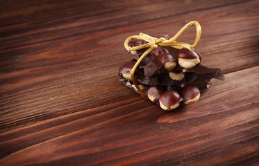 Chocolate pieces with nuts on wooden background