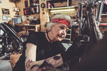 Fototapeta na wymiar Serene female retiree making machine maintenance