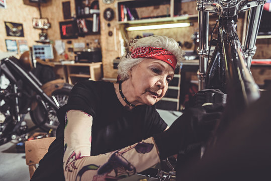 Serene female retiree making machine maintenance