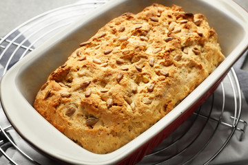 Tasty loaf of beer bread in baking dish on table