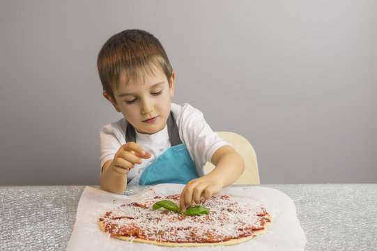 Boy is prepearing pizza
