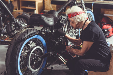 Calm granny making motorcycle maintenance