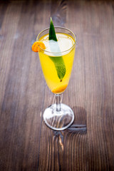 cocktail with physalis in glass on wooden background