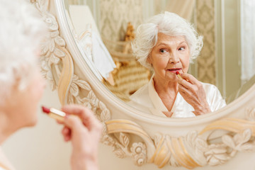 Old lady doing make-up at home