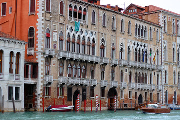 View of the Grand Canal with gondolas and colorful facades of old medieval houses from the Rialto Bridge in Venice, Italy. Venice is a popular tourist destination of Europe