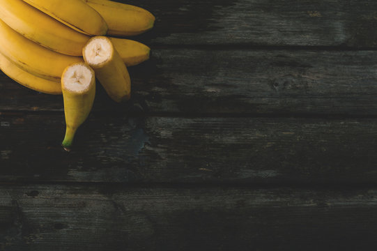 Bunch of fresh bananas on an old wooden table. Selective focus and small depth of field.