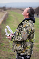Drone pilot. Man flying drone in countryside.