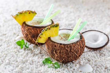 Delicious pinacolada in coconut with pineapple and mint leaves