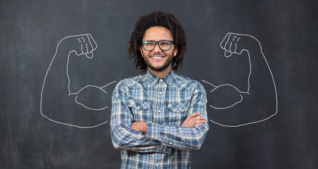 Young man against the background of depicted muscles on chalkboard © Myvisuals