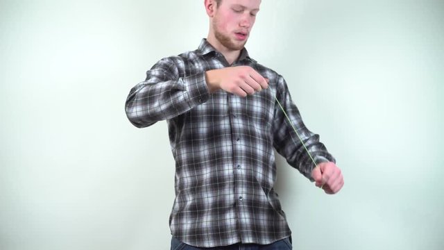 Young guy with beard and yoyo. Game for teenagers on sleight of hand. Young bearded man is played in his spare time, so as not to be bored. Modern entertainment and relaxation