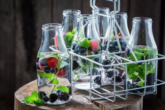 Fresh water in bottle with raspberries, blueberries and blackberries