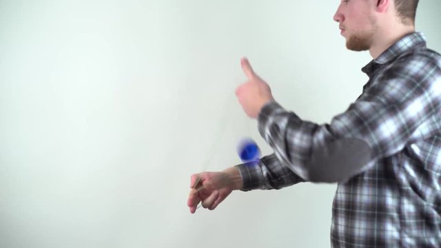 Yoyo specialist. Single man playing with a yoyo in studio. Guy a virtuoso playing with a toy yo-yo. Young boy enjoys his hobbie. Could play