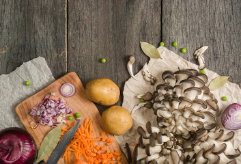 ingredients for vegetable soup. vegetables cucumber onions potatoes carrots mushrooms peas spices in the section on gray wooden background