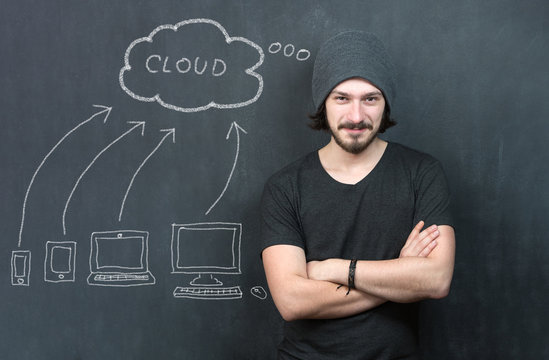 Portrait of man with cloud computing diagram on the chalkboard. Cloud Computing Concept on Chalkboard