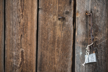 Detail of the old door of the barn with open padlock which hanging on the bracket. 