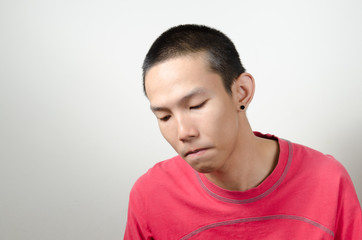Obraz premium Unhappy Asian young man Isolated on white