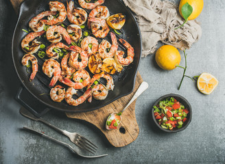 Seafood dinner. Grilled tiger prawns in cast iron grilling pan with lemon, leek, chili pepper and...