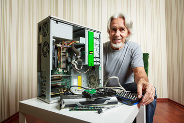 Senior Man Assembling A Desktop Computer