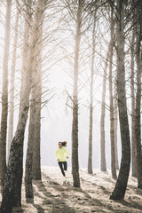 Fit young woman running on the forest.