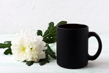 Black coffee mug mockup with white chrysanthemum