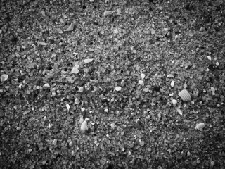 Black abstract natural sandy beach closeup, volcanic seacoast background. Space surface for text