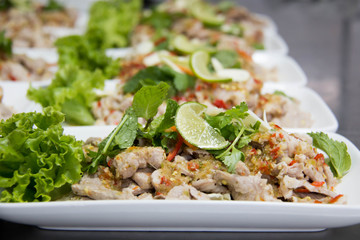  Spicy  pork salad with dried chili and garnished with mint.