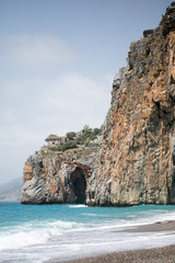 Fototapeta na wymiar Mediterranean beach with turqouise sea and rocks on shore