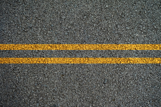 Double yellow lines on the asphalt road in the middle.