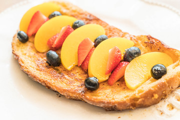 french toast with peach, strawberry and blueberries