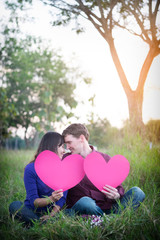 Loving couple. Beautiful young love couple holding paper hearts and smiling in outdoor nature vintage tone, valentine concept