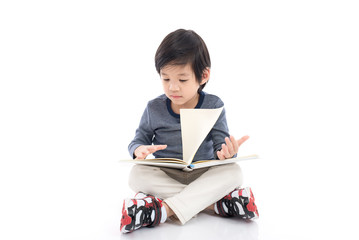Cute asian boy reading a book on white background isolated