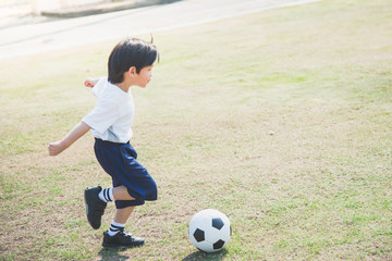 boy kicking football