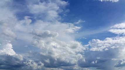 Clear blue sky with soft white clouds