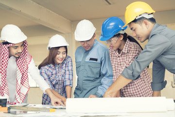 Asian engineers were consulted together and plan in construction site