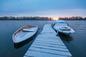 boat harbor in the winter on the lake, snow-covered bridge