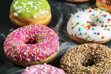 colored donuts with different fillings on a black background
