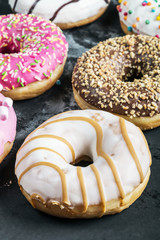 different colored donuts with different fillings on a black background