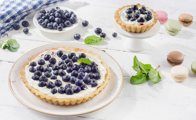 Cakes with blueberries and whipped cream and macaroons