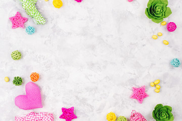 Spring background with colorful decoration. Frame with flowers,  ribbons, candys and other accessories. Child concept. Flat lay, top view