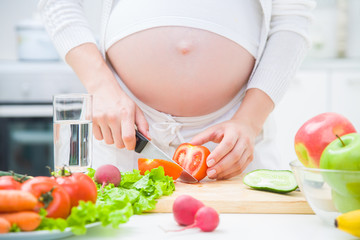 Obraz na płótnie Canvas Pregnant woman cooking