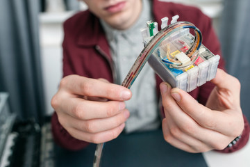 Colorful cartridge refilling at office closeup. Unrecognizable man fixing ink-jet supply system,...