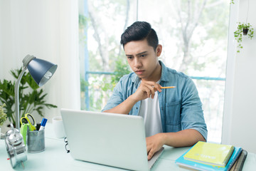 Student doing homework and preparing exam at home.