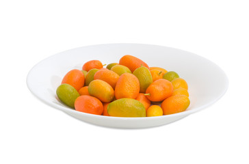 Kumquats on white dish on a light background