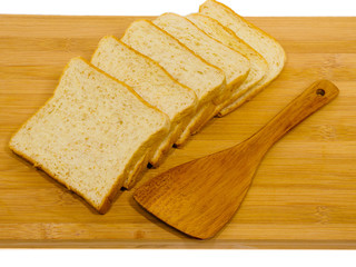 Side view of slices of toast bread on breadboard wooden, isolated on white background