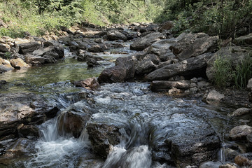 Small waterfall of mountain river in summer